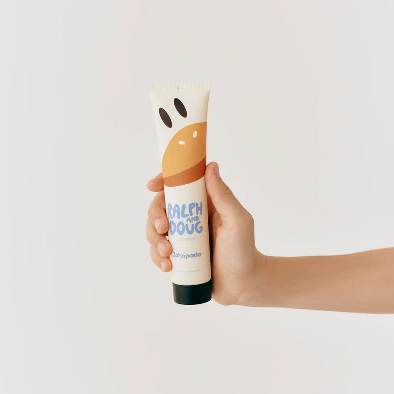 Kinderhand hält eine Tube DOUG