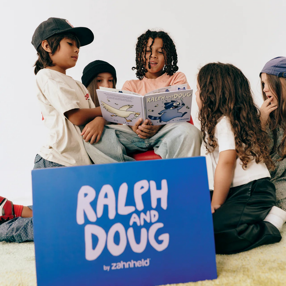 Zwei Jungen in karierten Jacken, einer putzt mit RALPH, der andere hält DOUG