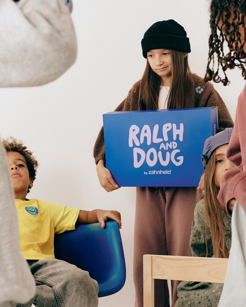 Mädchen hält die Bundle Box Ralph and Doug, um sie herum Kinder