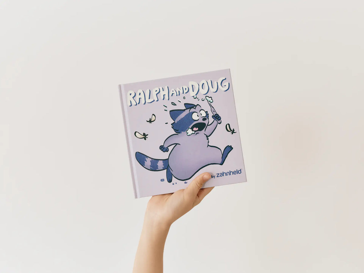 Hand hält das Kinderbuch Ralph and Doug hoch